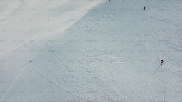 Skiers and snowboarders descend snowy mountain at riksgransen, Sweden