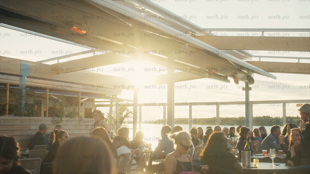 Summer evening on a rooftop patio in Luleå: Friends and family enjoying drinks and conversation