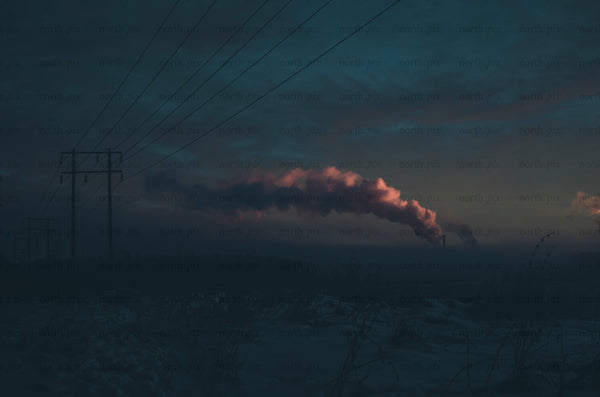 Power lines and factory smoke at dusk in winter