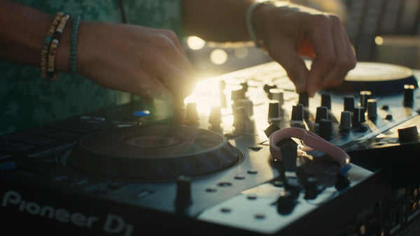 DJ mixing music at a summer sunset event