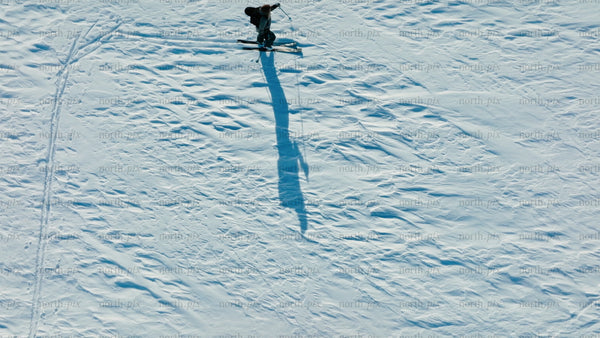 Skier carving down snowy slope on sunny winter day, riksgransen, Sweden