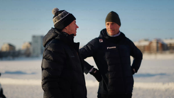 Two men talking on a frozen lake in Luleå on a bright winter day
