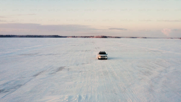 Driving on frozen ice road in Luleå archipelago at sunset