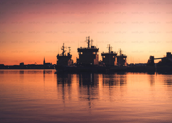 Icebreaker ships docked in harbor at sunset