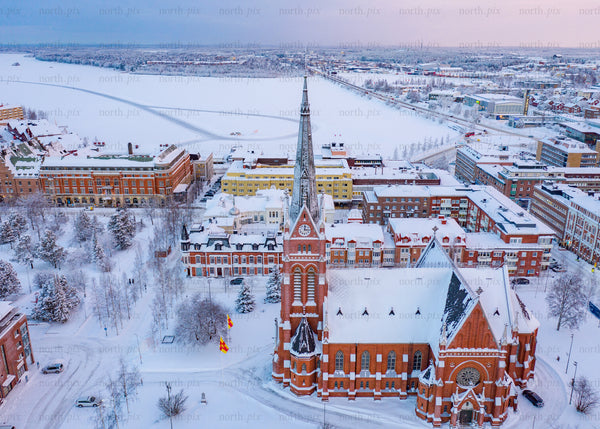 Aerial view of snowy Luleå cityscape and cathedral during winter