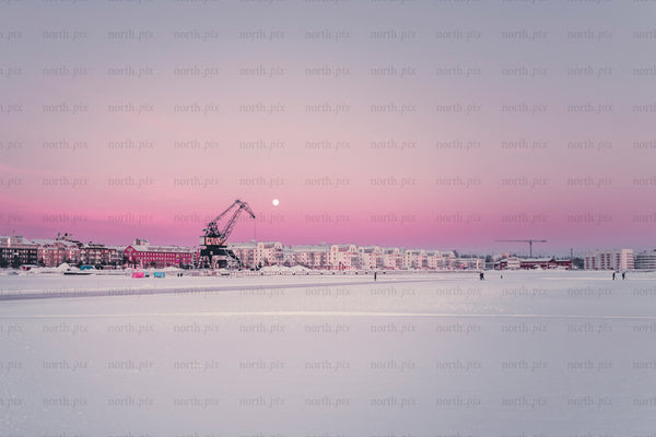 Harbor crane and waterfront buildings at sunrise