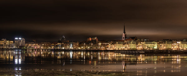 Night waterfront skyline with church spire and reflections