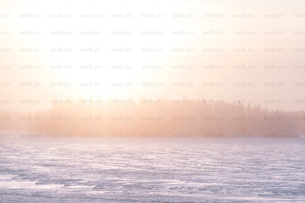 Sunrise over frozen lake and tree-covered island