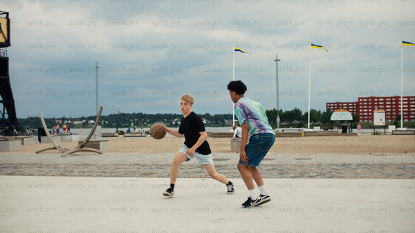 Urban summer basketball: Teenagers enjoying a game by the beach in Luleå