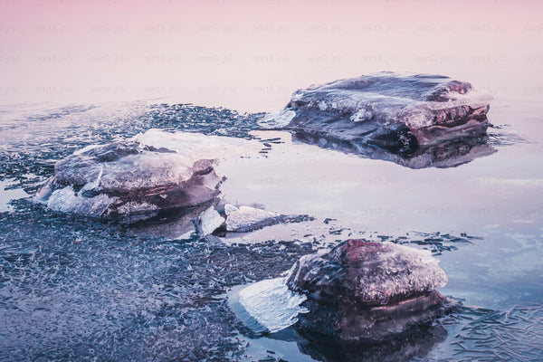 Ice formations on a partially frozen lake at sunrise
