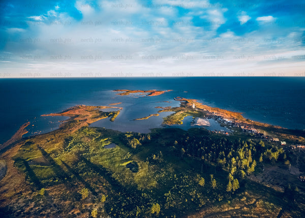 Drone view of coastal islands at sunset with forest and water