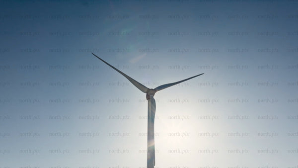 Rotating wind turbine against blue sky, clean energy generation