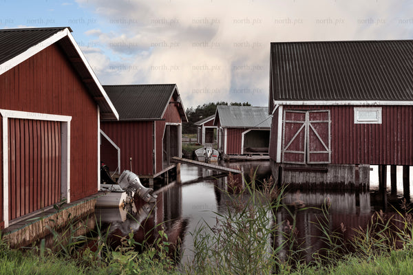 Red boathouses on piers in summer evening