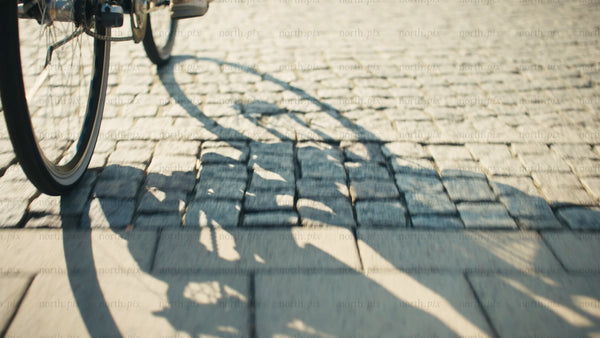 Woman cycles through Luleå on a sunny summer day with shopping bag