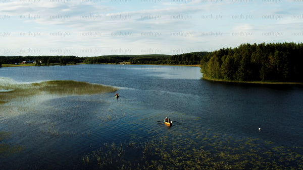 Summer evening canoe trip on a calm lake in Luleå