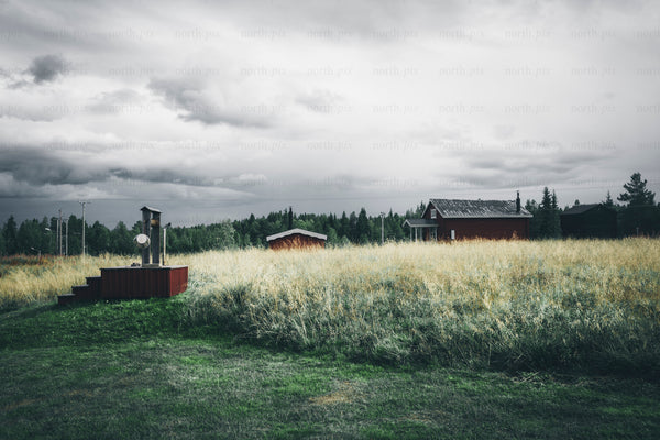 Red house on grassy field, late summer overcast