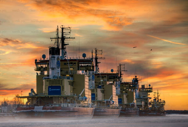 Line of icebreaker ships moored at sunset