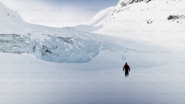 Man walking towards glacier in snowy Riksgränsen