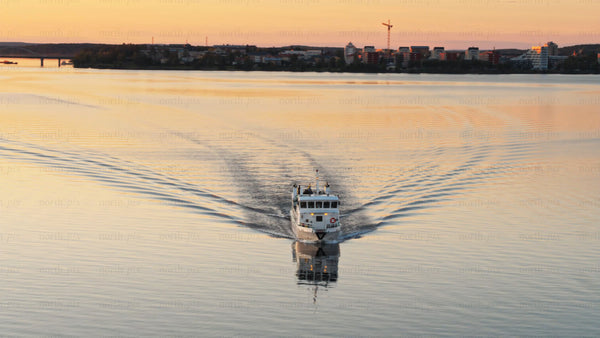 Golden hour ferry commute across the Luleå river in Luleå on a summer evening