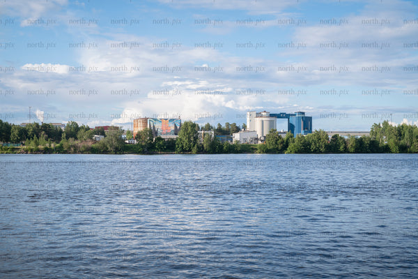 Industrial complex on riverbank in summer afternoon