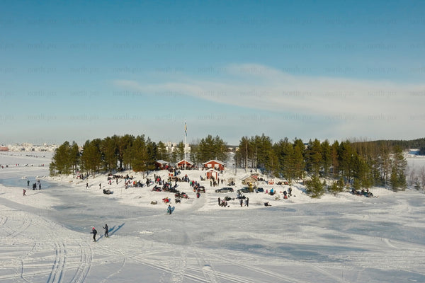 Snowy Luleå city center park with people enjoying winter activities and forested islands