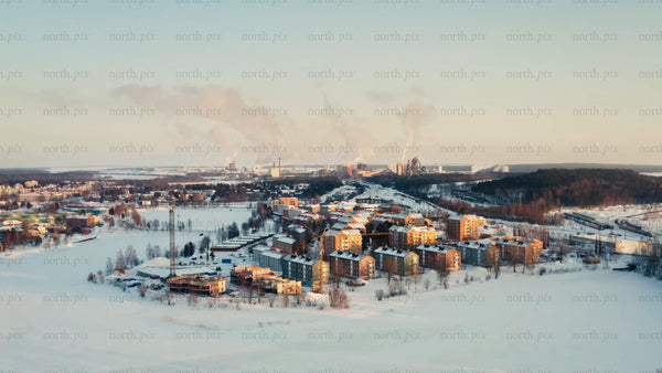 Aerial view of Luleå: Winter landscape, industrial area, and residential buildings at sunset