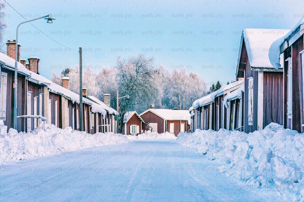Row of wooden houses on snowy street, winter morning