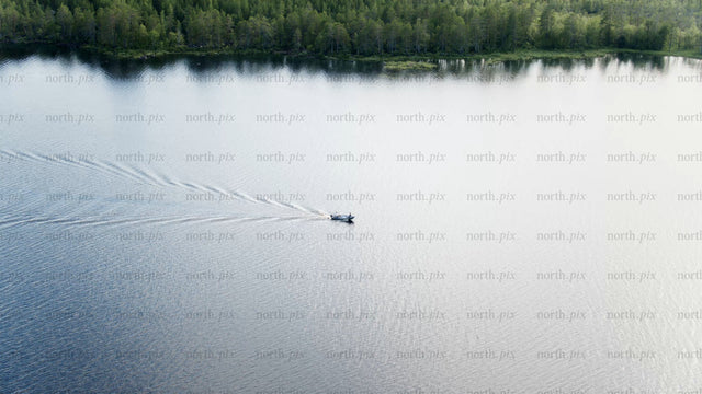 Summer evening boat trip on a calm lake near Luleå