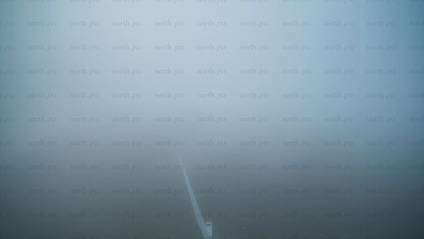 Wind turbine emerging from fog: Aerial view of renewable energy in Haraholmen