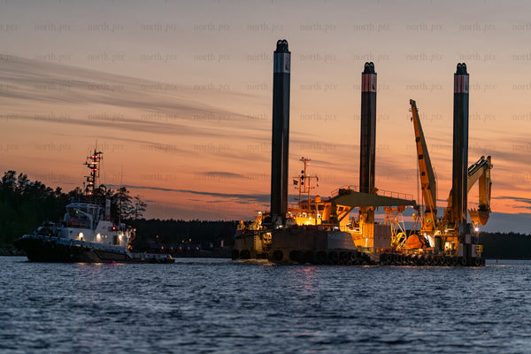 Offshore jack-up barge and tugboat at sunset, Baltic Sea