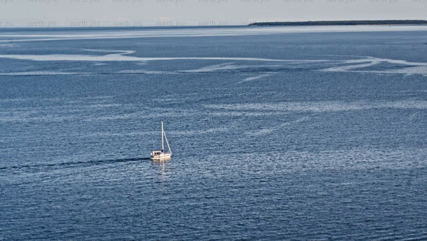 Summer evening sailboat in Luleå: Calm blue waters and island views