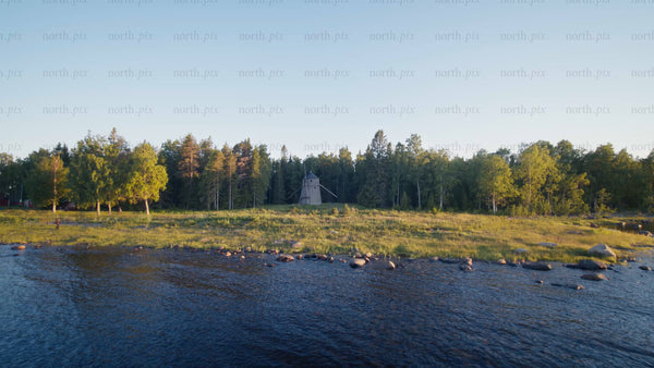 Summer evening drone view of windmill on forested island in Luleå archipelago