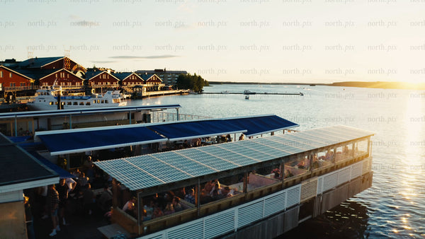 Summer evening in Luleå: People enjoying the sunset by the water. Aerial drone footage.