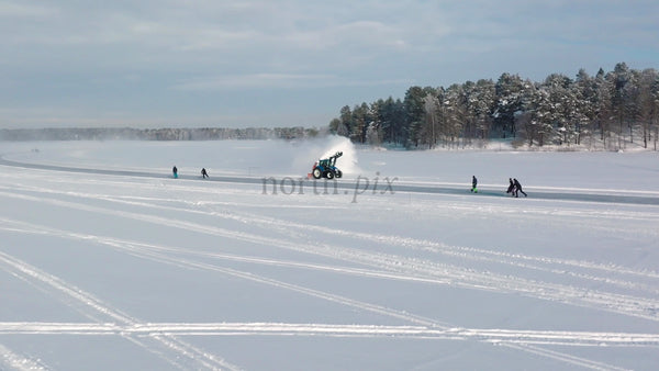 Tractor Clearing Snow on Frozen Lake in Lulea, Sweden, With People Skating and Kick Sledding