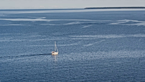 Summer evening sailboat in Luleå: Calm blue waters and island views