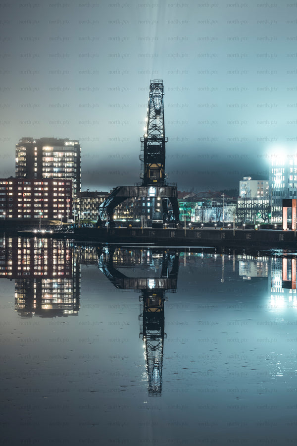 Industrial harbor crane with reflection at night