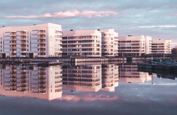 Modern waterfront apartments with glass balconies at sunset