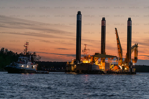 Offshore jack-up barge and tugboat at sunset, Baltic Sea