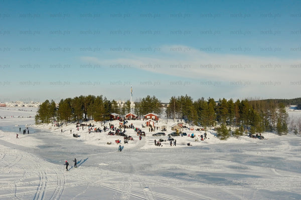 Snowy Luleå city center park with people enjoying winter activities and forested islands