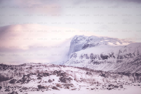Stora sjöfallet - snow-covered mountain at sunrise with rocky foreground