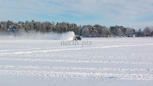 Tractor Clearing Snow on Frozen Lake in Lulea, Sweden Winter Landscape