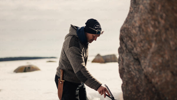 Man cooking on a portable stove by a frozen lake in Luleå archipelago winter
