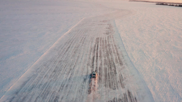 Driving car on frozen ice road in Luleå archipelago during winter sunset
