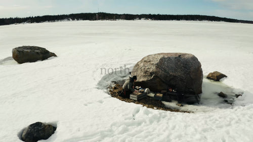 Vinter i Luleå: Flygfoto från drönare av person vid frusen sjö och snöskoter i Sverige