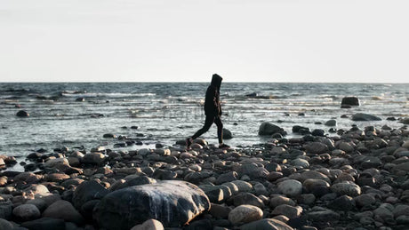 Lone Person Walks Along Rocky Beach in Luleå Archipelago During Summer Evening