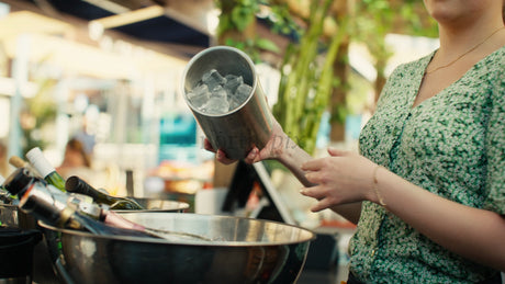 Bartender Pours Ice into a Bucket at an Outdoor Bar on a Sunny Summer Day in Lulea, Sweden