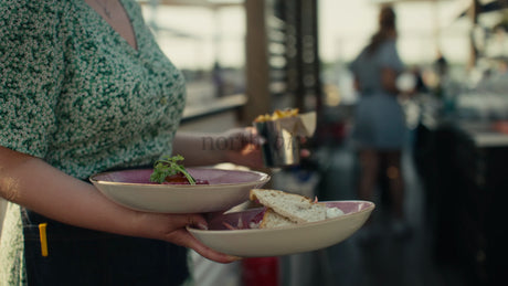 Waitress Carrying Food to Customers at Outdoor Restaurant in Lulea, Sweden