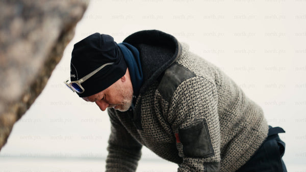 Man preparing fire in snowy Luleå archipelago, winter day