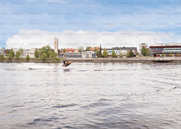 Jet ski on river near waterfront buildings in summer