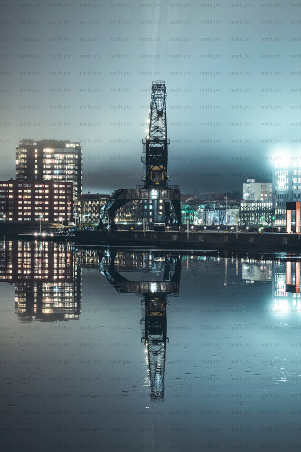 Industrial harbor crane with reflection at night
